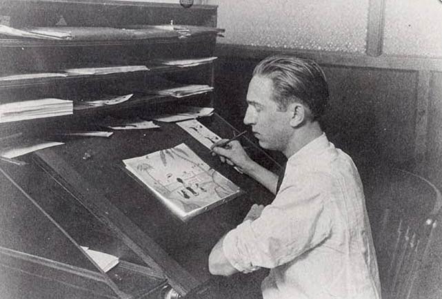 photograph of Walt Disney at his drawing board